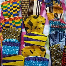 photograph of pile of colorful mask in African textiles